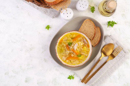 Téléchargez les photos : Soupe de poulet fraîche aux légumes et pâtes stellines dans un bol avec carotte et persil. Vue de dessus, plan plat - en image libre de droit