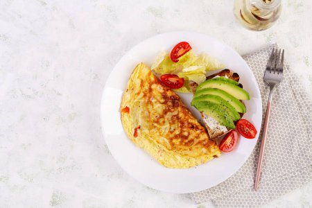 Photo for Omelette with tomatoes and toast with avocado on white plate.  Frittata - italian omelet. Top view, flat lay - Royalty Free Image