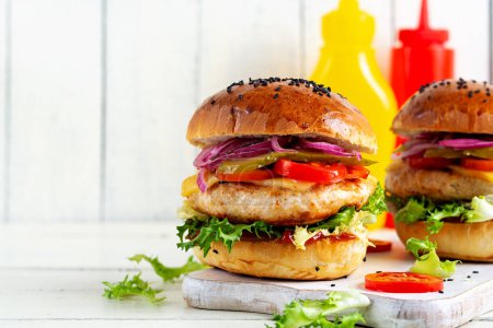 Photo for Chicken hamburger. Sandwich with chicken burger, tomatoes, cheese, pickled cucumber and lettuce. Cheeseburger. - Royalty Free Image