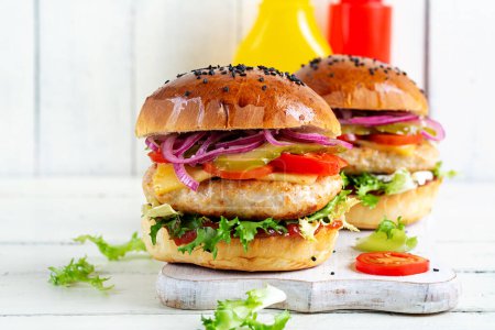 Téléchargez les photos : Hamburger au poulet. Sandwich avec hamburger de poulet, tomates, fromage, concombre mariné et laitue. Cheeseburger. - en image libre de droit