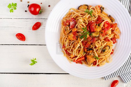 Téléchargez les photos : Pâtes italiennes classiques spaghetti marinara aux moules et saumon sur table blanche. Pâtes spaghetti à la sauce marinara. Vue de dessus, vue aérienne - en image libre de droit