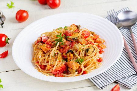 Photo for Classic italian pasta spaghetti marinara with mussels and salmon on white table. Spaghetti pasta with sauce marinara. - Royalty Free Image