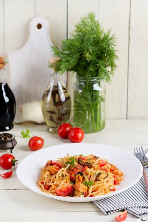 Photo for Classic italian pasta spaghetti marinara with mussels and salmon on white table. Spaghetti pasta with sauce marinara. - Royalty Free Image
