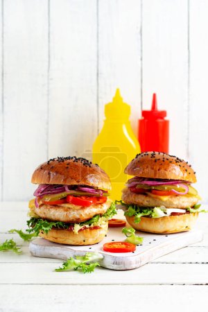 Photo for Chicken hamburger. Sandwich with chicken burger, tomatoes, cheese, pickled cucumber and lettuce. Cheeseburger. - Royalty Free Image