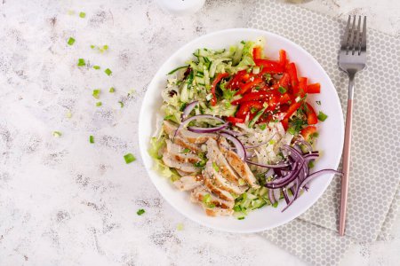 Téléchargez les photos : Salade fraîche avec poitrine de poulet grillée, filet et laitue, daikon, oignons rouges, concombre et sésame. Menu sain pour déjeuner. Alimentation diététique. Vue du dessus - en image libre de droit