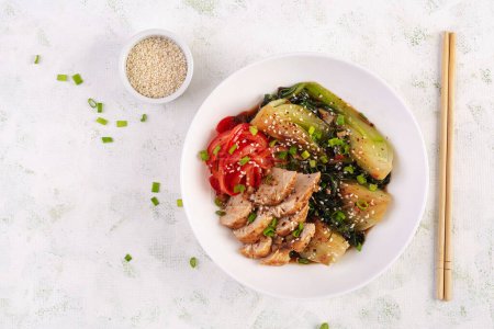 Photo for Stir fried of chicken, sweet peppers and bok choy in a bowl on the table. Stir fry pak choi. Asian food. Top view - Royalty Free Image