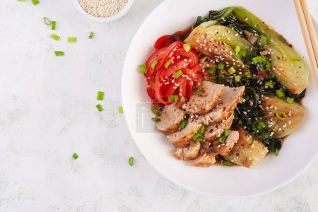 Photo for Stir fried of chicken, sweet peppers and bok choy in a bowl on the table. Stir fry pak choi. Asian food. Top view - Royalty Free Image