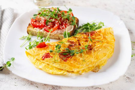 Photo for Omelette with cheese and toast with tomatoes on white plate.  Frittata - italian omelet. - Royalty Free Image