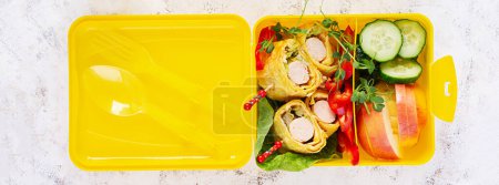 Téléchargez les photos : Boîte à lunch scolaire avec rouleau de saucisse en omelette à la lavande. Boîte à lunch. Déjeuner Keto. Vue de dessus, plan plat - en image libre de droit