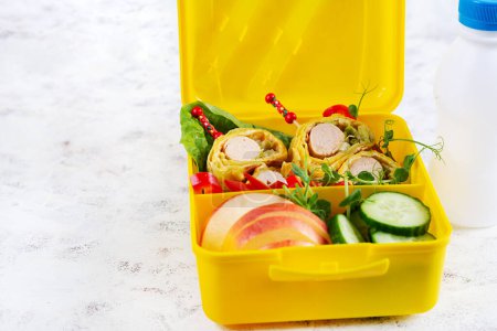 Téléchargez les photos : Boîte à lunch scolaire avec rouleau de saucisse en omelette à la lavande. Boîte à lunch. Déjeuner Keto. - en image libre de droit