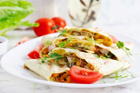Foto de Envoltura de Quesadilla Mexicana con pollo, maíz y pimiento dulce en plato blanco. - Imagen libre de derechos