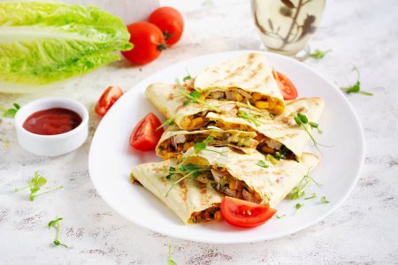 Foto de Envoltura de Quesadilla Mexicana con pollo, maíz y pimiento dulce en plato blanco. - Imagen libre de derechos