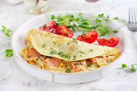 Foto de Desayuno saludable. Quesadilla con tortilla, salmón y tomates en rodajas. Keto, almuerzo cetogénico. - Imagen libre de derechos