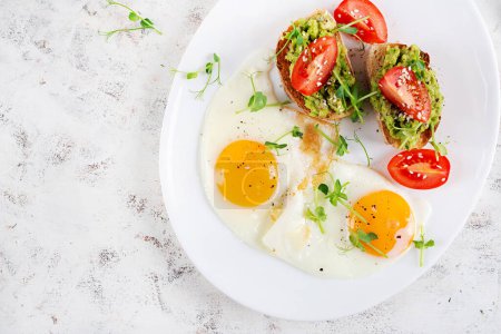 Photo for Keto breakfast. Fried eggs and toast with guacamole and tomatoes. Top view, flat lay - Royalty Free Image