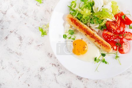 Téléchargez les photos : Petit déjeuner Keto. Œuf frit et saucisse de poulet et salade fraîche. Vue de dessus, plan plat - en image libre de droit