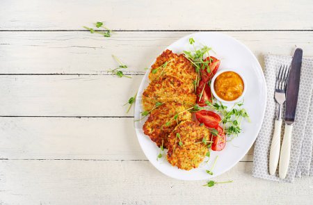 Photo for Potato fritters or pancakes served with sauce. European cuisine. Kosher eating. Vegan food. Top view, flat lay - Royalty Free Image
