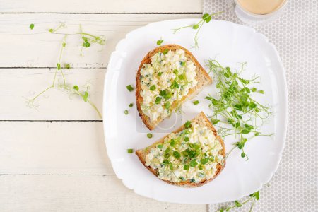 Foto de Deliciosas tostadas con huevo cocido al paté, pepino y queso crema en un plato blanco. Comida saludable, desayuno. Comida dietética Keto. Comida sabrosa. Vista superior - Imagen libre de derechos