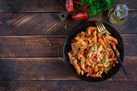 Photo for Classic italian pasta penne arrabbiata with vegetables on wooden table. Penne pasta with sauce arrabbiata. Top view, overhead - Royalty Free Image