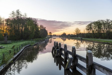 Téléchargez les photos : Lever de soleil sur le canal de l'eau dans la municipalité de Noordoostpolder, Flevoland, Pays-Bas - en image libre de droit