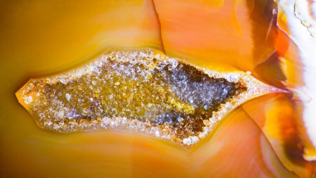 Photo for Small geode with quartz crystals inside agate gemstone cross section detail. Closeup a beautiful cavity in cut gem with golden yellow or orange polished surface. Silica mineral from northeast Bohemia. - Royalty Free Image