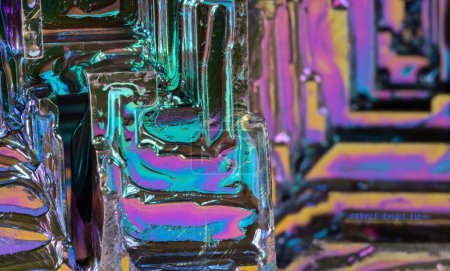 Primer plano del cristal de tolva del elemento químico bismuto en fondo iridiscente de color. Hermoso detalle de textura de metal pesado diamagnético quebradizo con superficie oxidada y utilizado en aleaciones. Química.