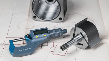 Blue micrometer screw gauge with digital display and metal parts on technical drawing background. Closeup of steel rotor with 3 vanes and stator of pump rotary compressor near accurate measuring tool.