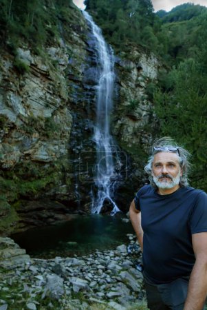 Téléchargez les photos : Homme sous la cascade Froda en Suisse - en image libre de droit