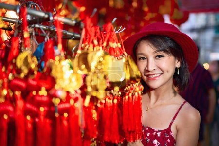 Foto de Thai woman posing with good luck charms at yaowarat china town in bangkok thailand during chinese new year - Imagen libre de derechos