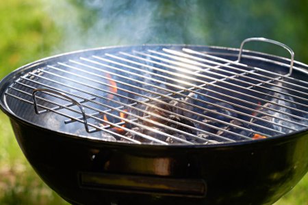 Téléchargez les photos : Grille de bouilloire au charbon de bois échauffement et prêt à cuire la nourriture dans la cour arrière - en image libre de droit