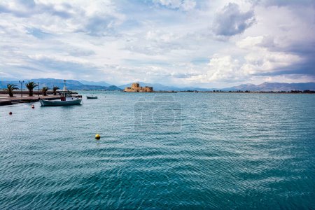 Traditional fishing boats and Bourtzi fortress in the picturesque city of Nafplio former capital of Greece, Argolida, Peloponnese.
