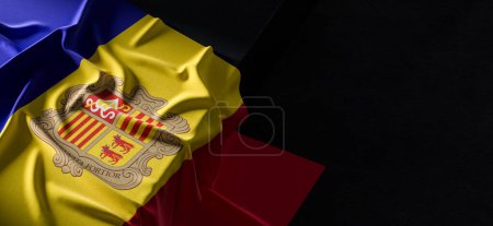 Flag of Andorra. Fabric textured Andorra flag isolated on dark background. 3D illustration