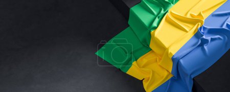 Flag of Gabon. Fabric textured Gabon flag isolated on dark background. 3D illustration