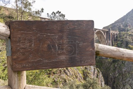 Foto de Un Ponte Ulla, España. Placa tallada en madera del viaducto de Gundian, un puente de piedra y hierro sobre el río Ulla - Imagen libre de derechos