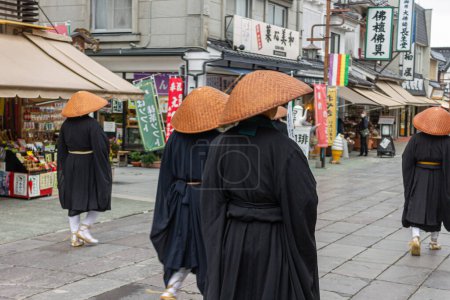 Téléchargez les photos : Nagano, Japon. Les moines bouddhistes japonais Zen de l'école Soto avec des chapeaux Kasa regardant la porte Sanmon à Zenko-ji, un temple bouddhiste - en image libre de droit