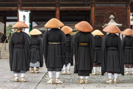 Téléchargez les photos : Nagano, Japon. Les moines bouddhistes japonais Zen de l'école Soto avec des chapeaux Kasa regardant la porte Sanmon à Zenko-ji, un temple bouddhiste - en image libre de droit
