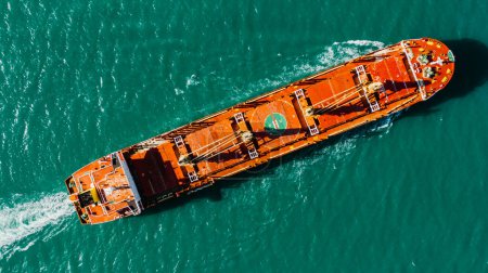 A large ship with grain is sailing on the sea, aerial view from top to bottom. Commercial international shipping, global business