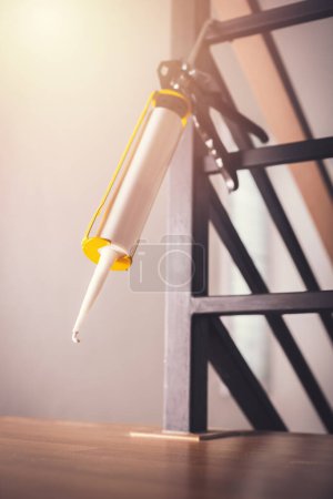 Téléchargez les photos : Closeup white silicone caulk cartridge and sealant gun - en image libre de droit