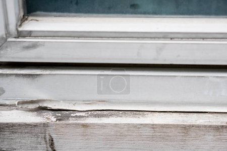 Photo for Closeup old and dirty white silicone caulk on the windows frame - Royalty Free Image