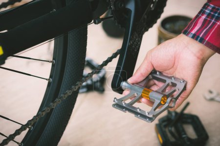 El hombre cambiando pedales de bicicleta. concepto de actualización de bicicleta de montaña.