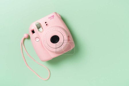 Foto de BANGKOK, TAILANDIA - 09 DE OCTUBRE DE 2019: La cámara instantánea rosa Fujifilm Instax mini 8 sobre fondo verde. - Imagen libre de derechos