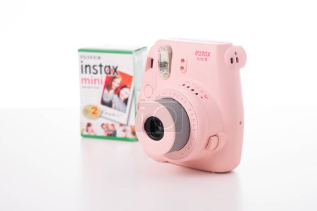 Foto de BANGKOK, TAILANDIA - 10 DE OCTUBRE DE 2019: La cámara instantánea rosa Fujifilm Instax mini 8 sobre fondo. - Imagen libre de derechos