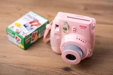 Photo for BANGKOK, THAILAND - OCTOBER 11, 2019: The pink Fujifilm Instax mini 8, instant camera with Instax Mini format (54 mm x 86 mm). - Royalty Free Image