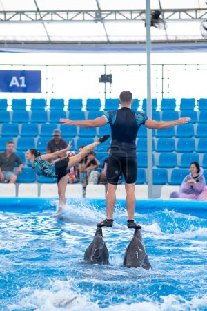Téléchargez les photos : CHONBURI, THAÏLANDE - 22 OCTOBRE 2019 : Des instructeurs jouent avec des dauphins au Pattaya Dolphinarium à Chonburi, en Thaïlande. Pattaya Dolphinarium est le meilleur spectacle de dauphins en Asie du Sud-Est. - en image libre de droit