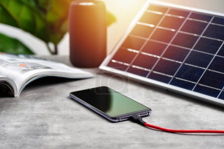 Charging the smartphone with solar energy. Green energy concept.