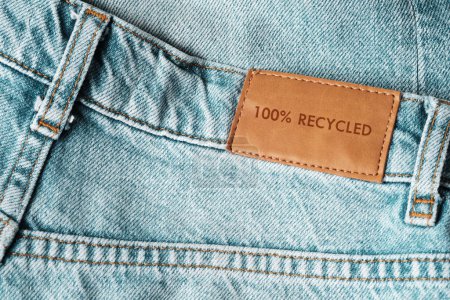 Téléchargez les photos : Jeans étiquetés 100 % recyclés. Mode durable, consommation consciente. - en image libre de droit