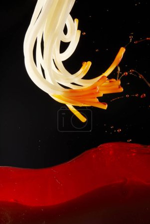 Photo for Close-up of jumping rice noodles with red chili oil and soup - Royalty Free Image