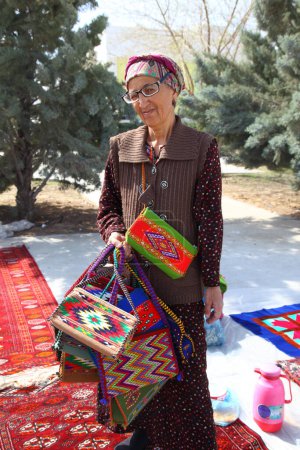 Téléchargez les photos : Ashgabat, Turkmenistan - Mart 15, 2022.  Portrait of old unidentified  Asian woman. Woman  sells national bags. Oriental bazaar.  Ashgabat, Turkmenistan -  Mart 15, 2022. - en image libre de droit