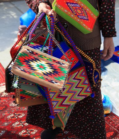 Téléchargez les photos : Sacs et tapis décoratifs faits à la main avec ornement traditionnel. Turkménistan. Marché Ashkhabad. - en image libre de droit