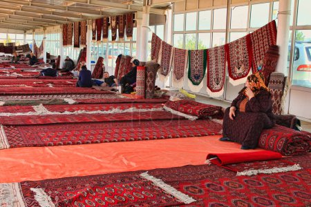 Téléchargez les photos : Ashgabat, Turkmenistan - Mart 15.   Pavilion selling Turkmen handmade carpets. Handmade carpets with traditional ornament. Turkmenistan. Ashkhabad market. - en image libre de droit