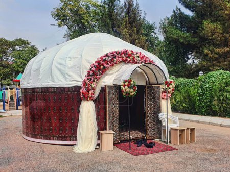Téléchargez les photos : Yourte de mariage asiatique, décorée avec des fleurs et des tapis faits à la main. - en image libre de droit